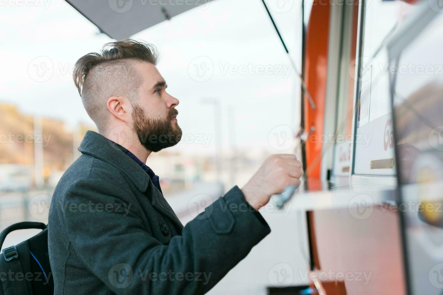 Portrait of man choosing fast food in food truck in the street. Meal, food industry and streetfood concept. photo