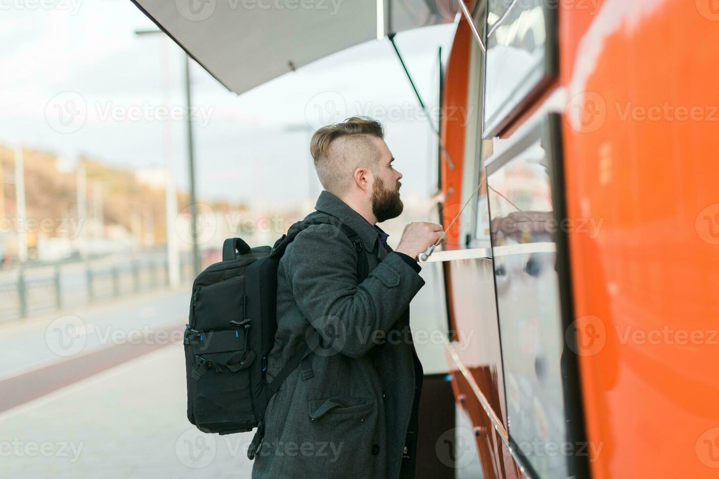Portrait of man choosing fast food in food truck in the street. Meal, food industry and streetfood concept. photo