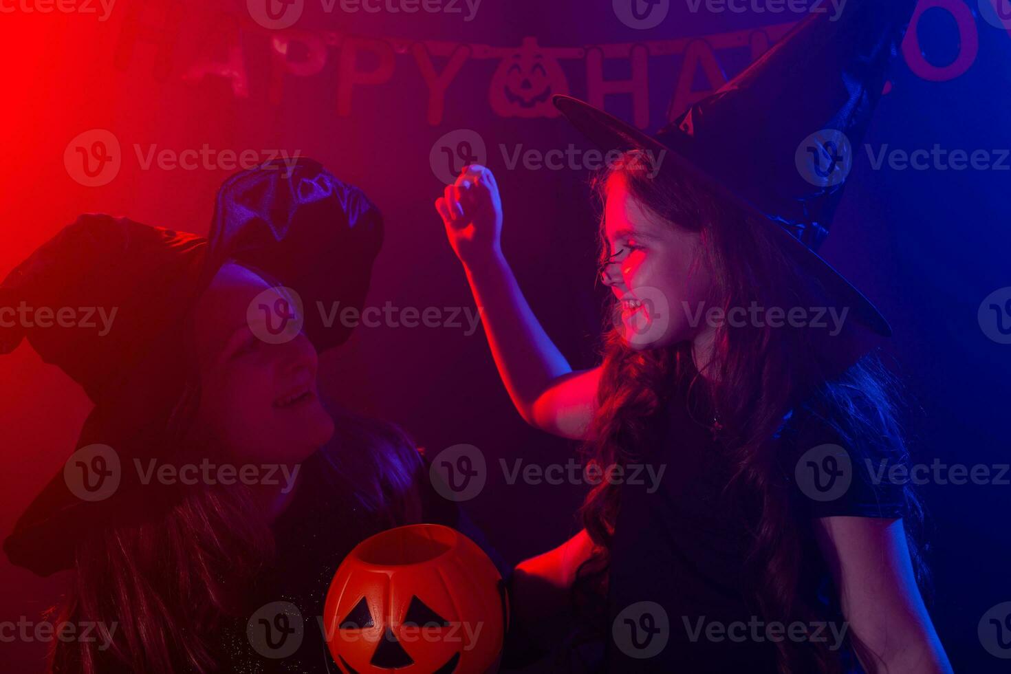 Funny child girl and woman in witches costumes for Halloween. photo