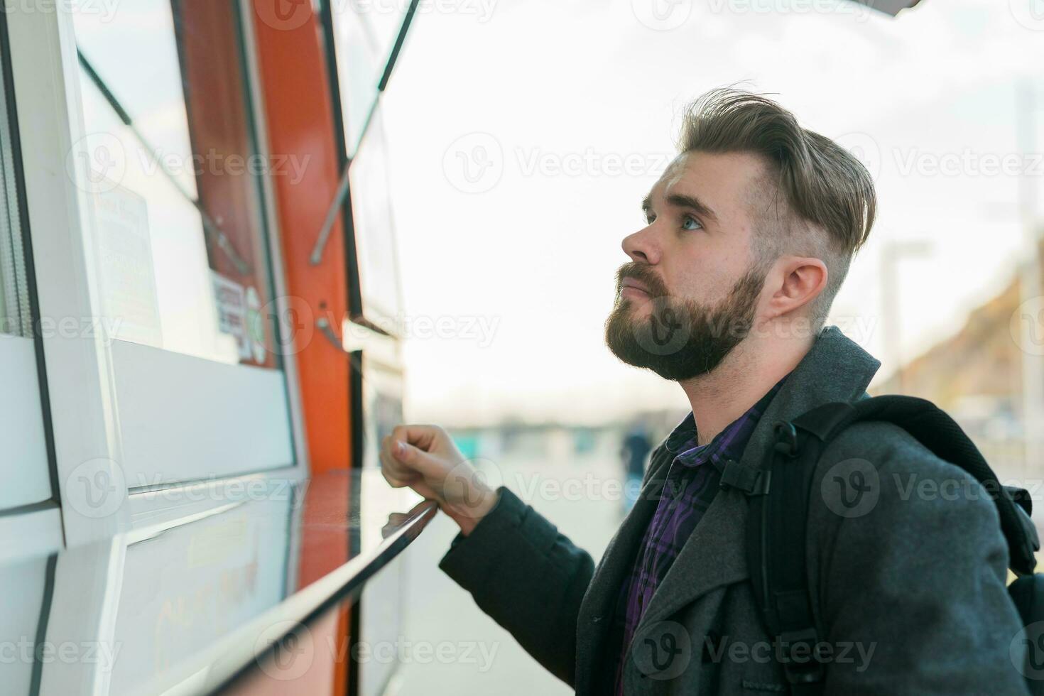 Portrait of man choosing fast food in food truck in the street. Meal, food industry and streetfood concept. photo