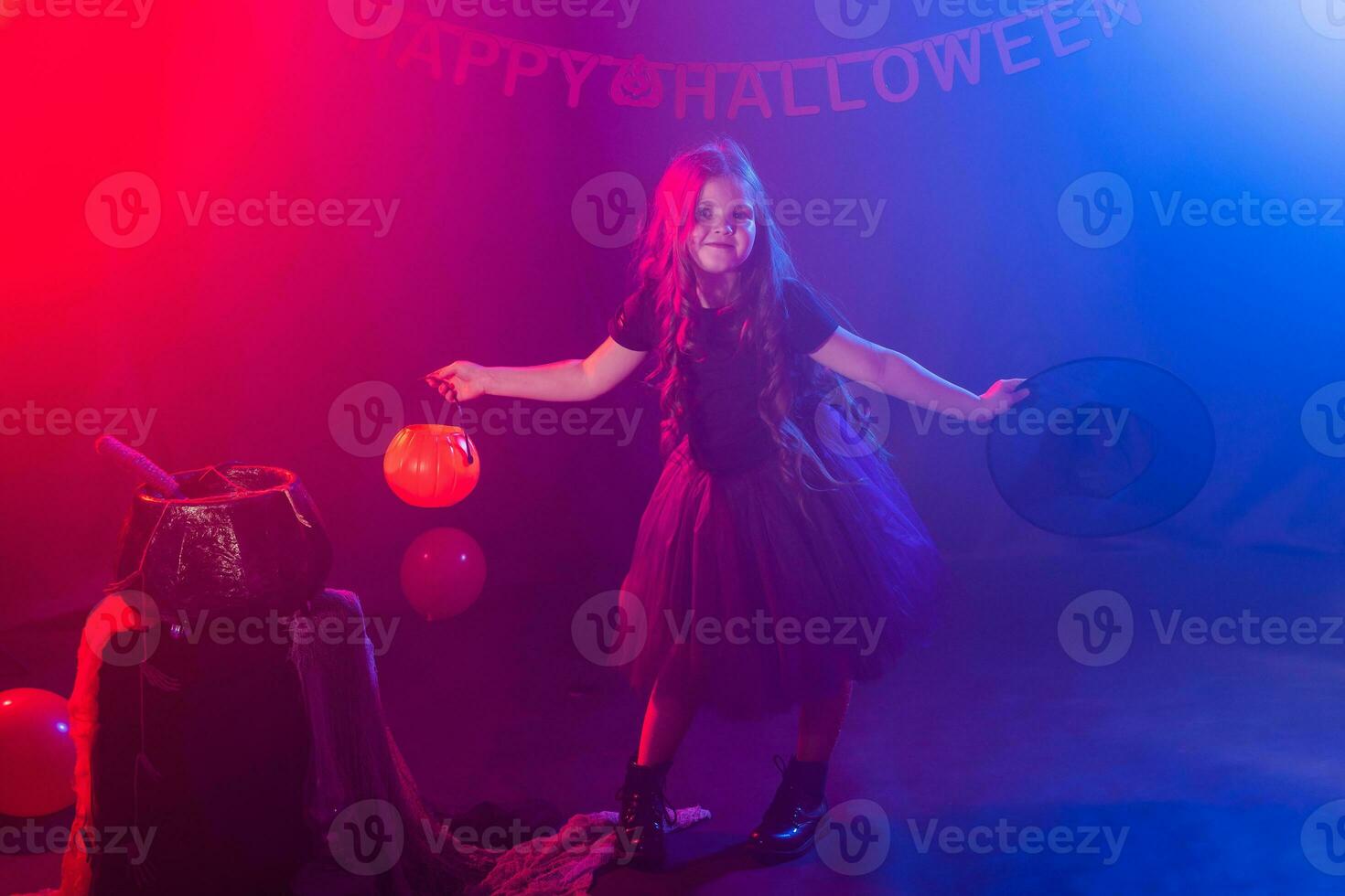 Little girl holds pumpkin jack on Halloween holiday. Kid girl wear witch costume. Fantasy, fairy tale and masquerade concept. photo