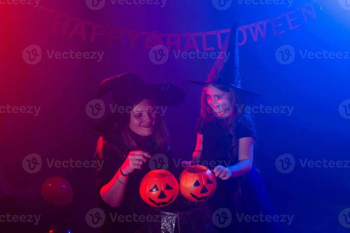 Funny child girl and woman in witches costumes for Halloween with pumpkin Jack. photo