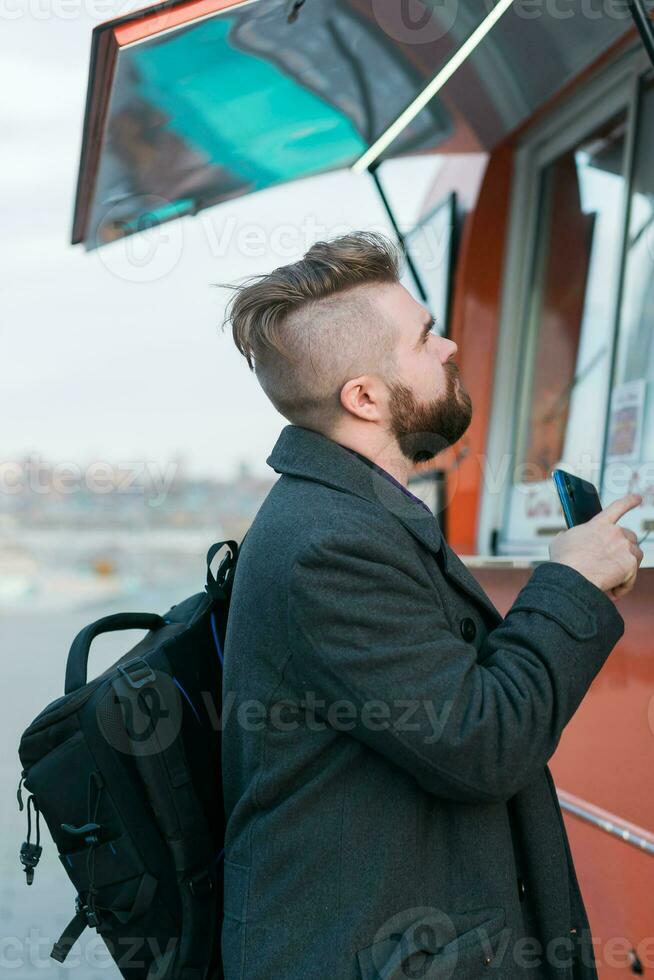 Portrait of man choosing fast food in food truck in the street. Meal, food industry and streetfood concept. photo