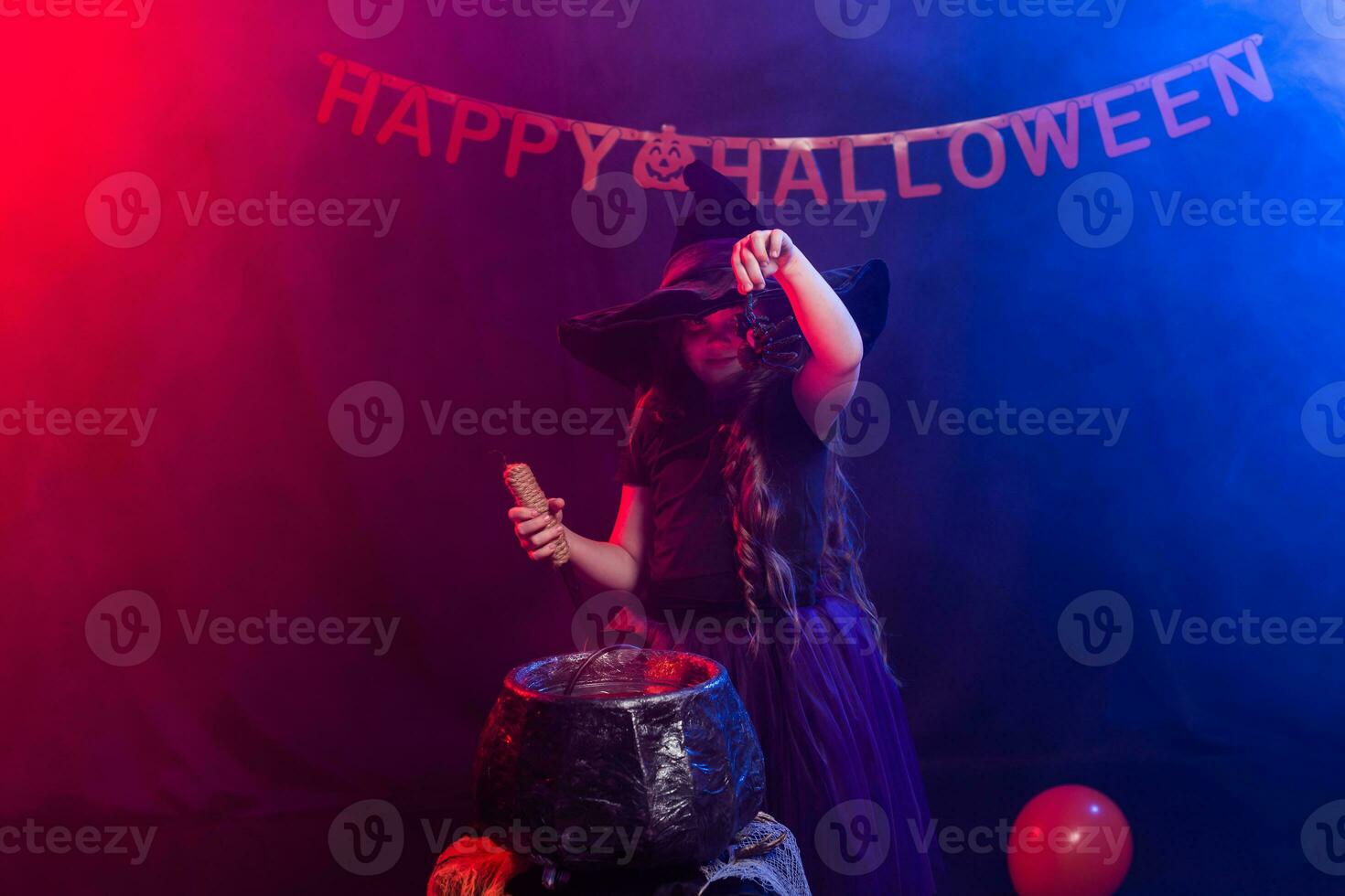 Funny child girl in witch costume for Halloween with pumpkin Jack. photo