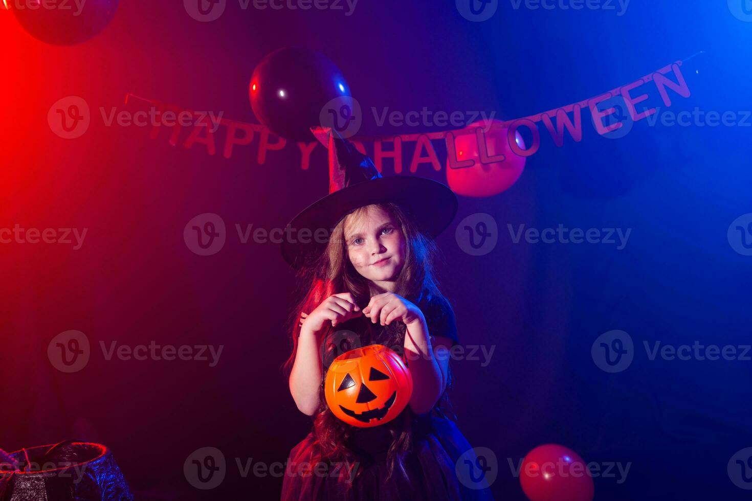 gracioso niño niña en bruja disfraz para Víspera de Todos los Santos con calabaza Jacobo. foto