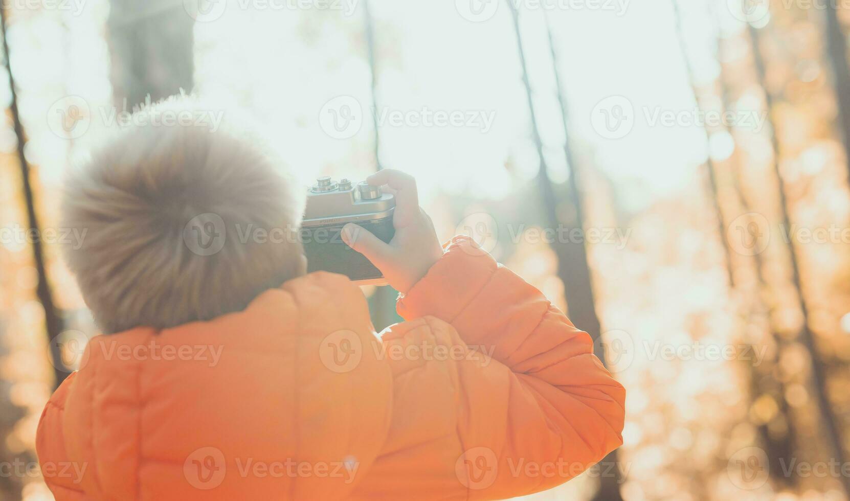 chico con retro cámara tomando imágenes al aire libre en otoño naturaleza. ocio y fotógrafos concepto foto