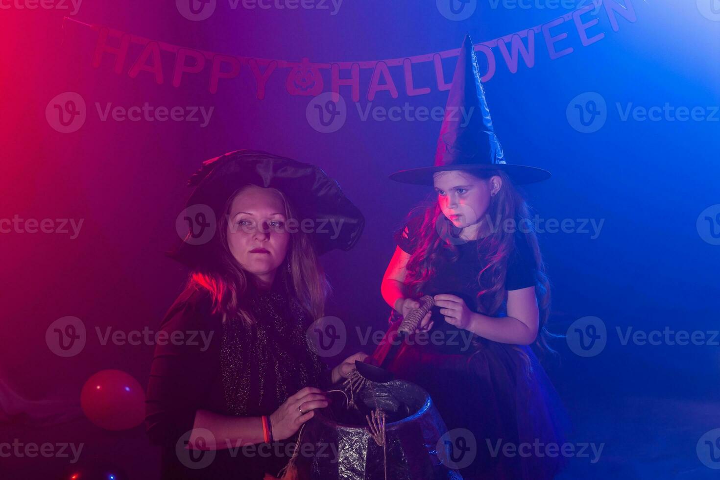 Funny child girl and woman in witches costumes for Halloween with pumpkin Jack. photo