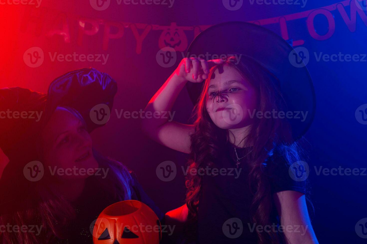 Funny child girl and woman in witches costumes for Halloween with pumpkin Jack. photo