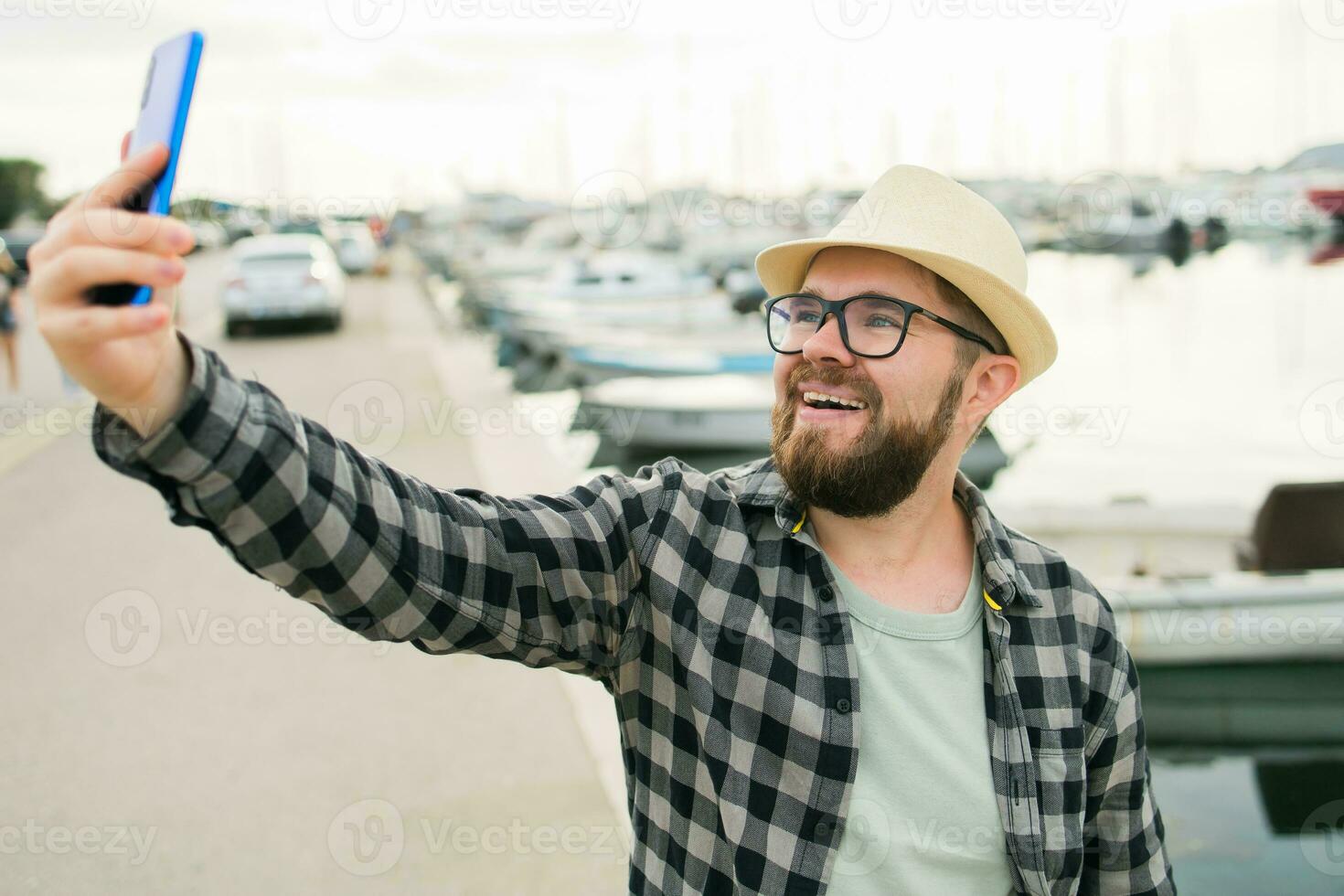 Traveller man taking selfie of luxury yachts marine during sunny day - travel and summer concept photo