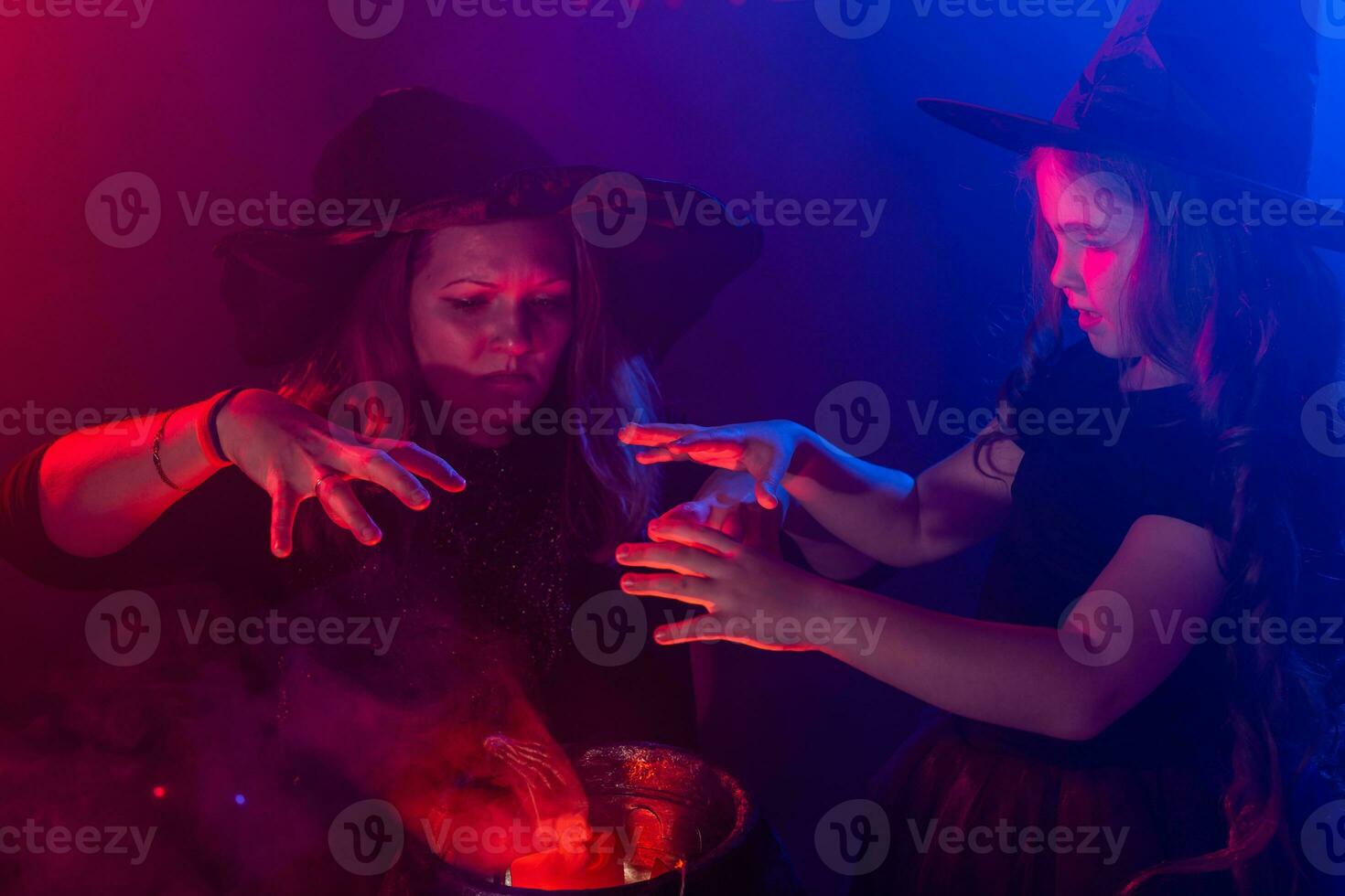 Funny child girl and woman in witches costumes for Halloween. photo