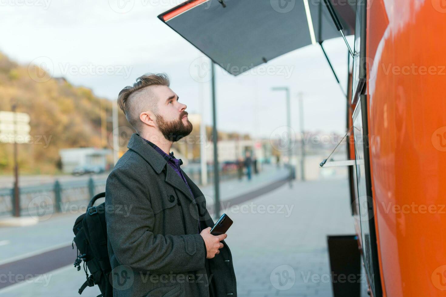 Portrait of man choosing fast food in food truck in the street. Meal, food industry and streetfood concept. photo