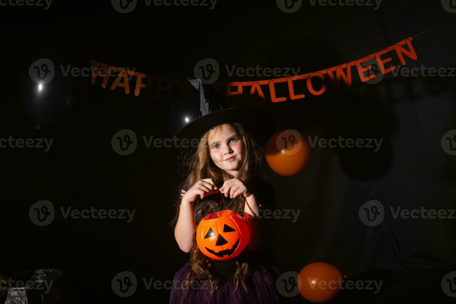 gracioso niño niña en bruja disfraz para Víspera de Todos los Santos con calabaza Jacobo. foto