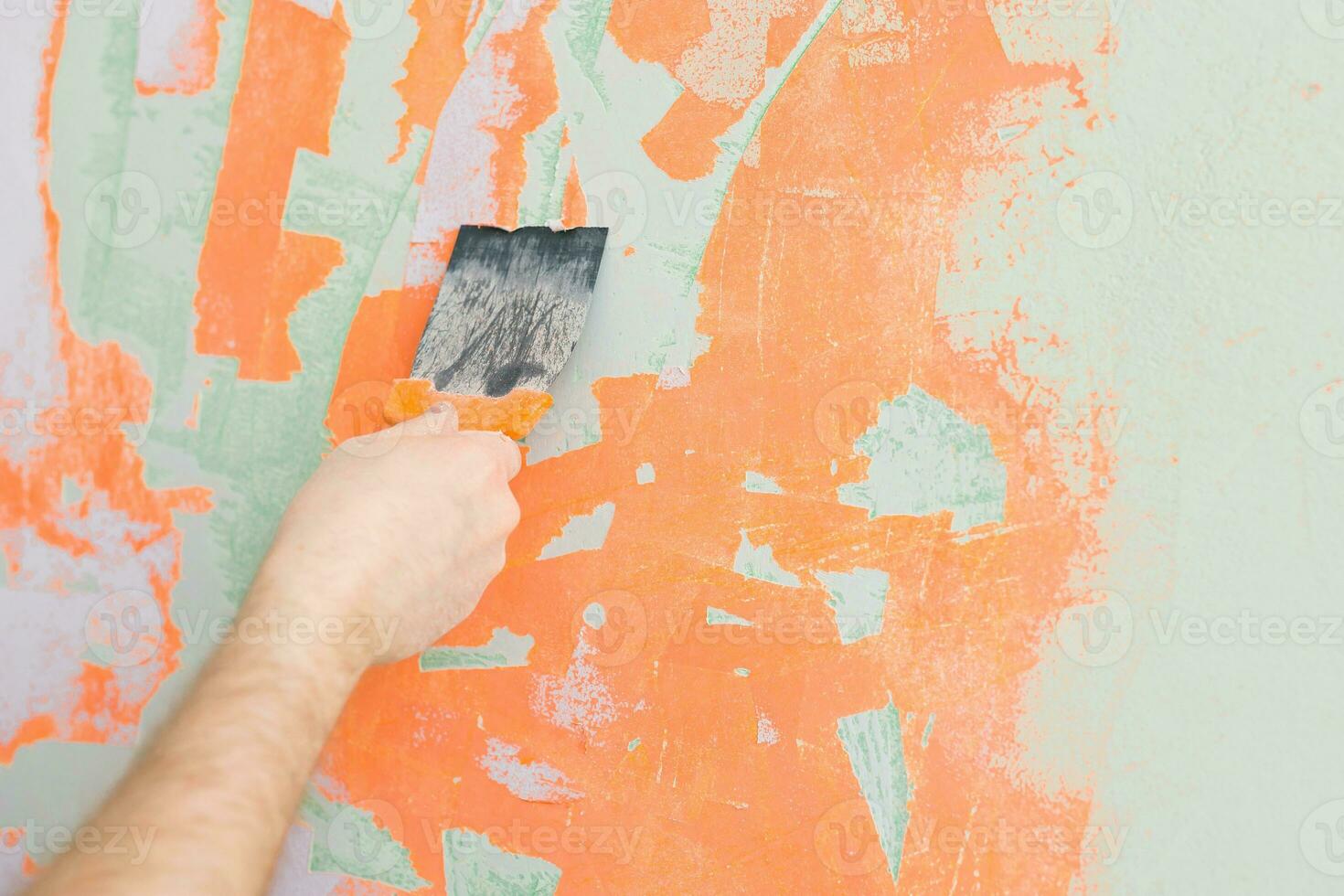 Close Up view of a man's hand plastering hole in a wall with spatula photo