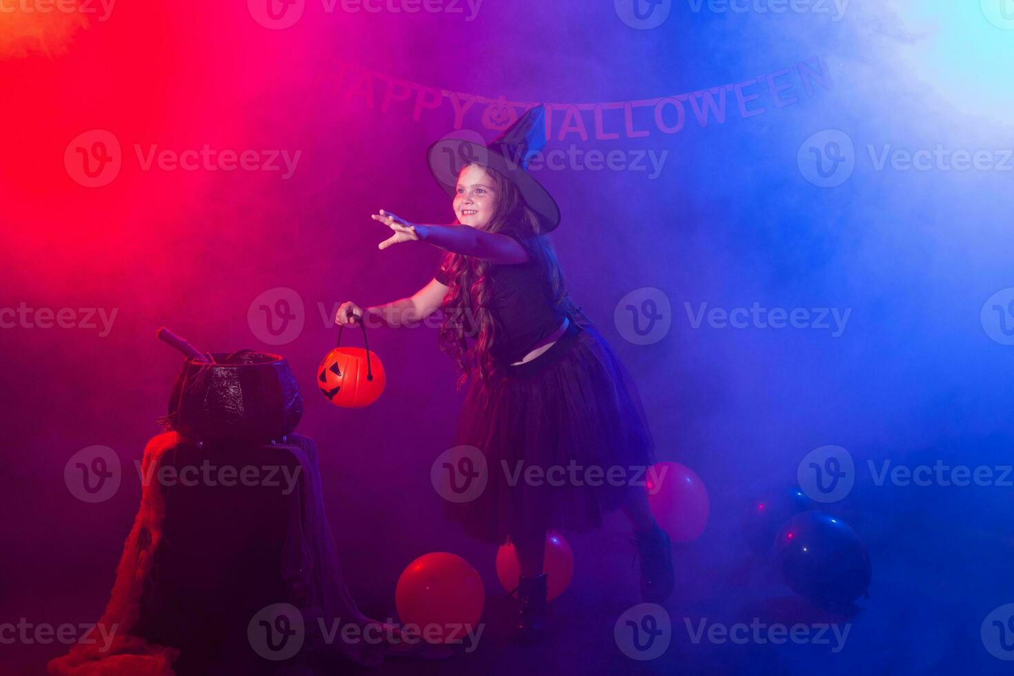 Funny child girl in witch costume for Halloween with pumpkin Jack. photo