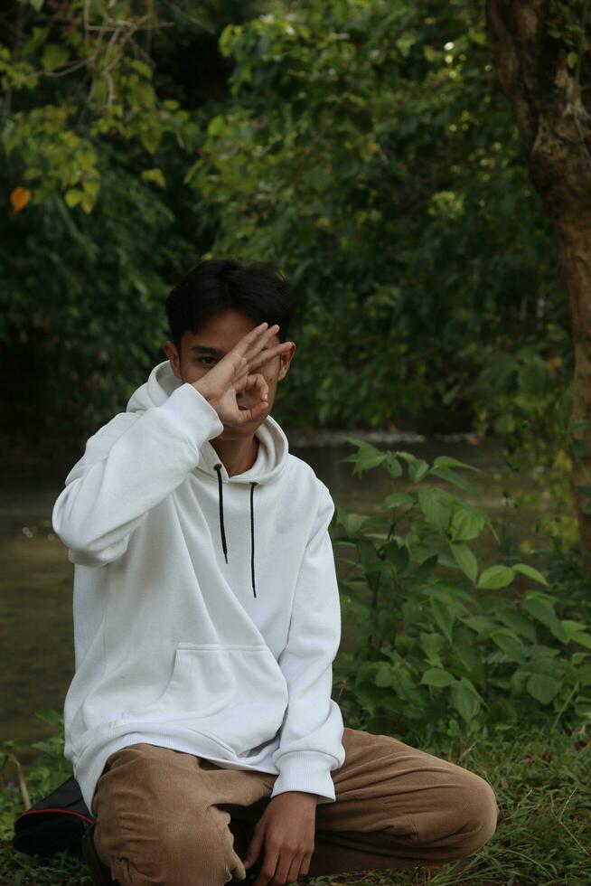 Gorontalo-Indonesia, Jan 2023 - Young man enjoying the morning atmosphere by the riverside photo