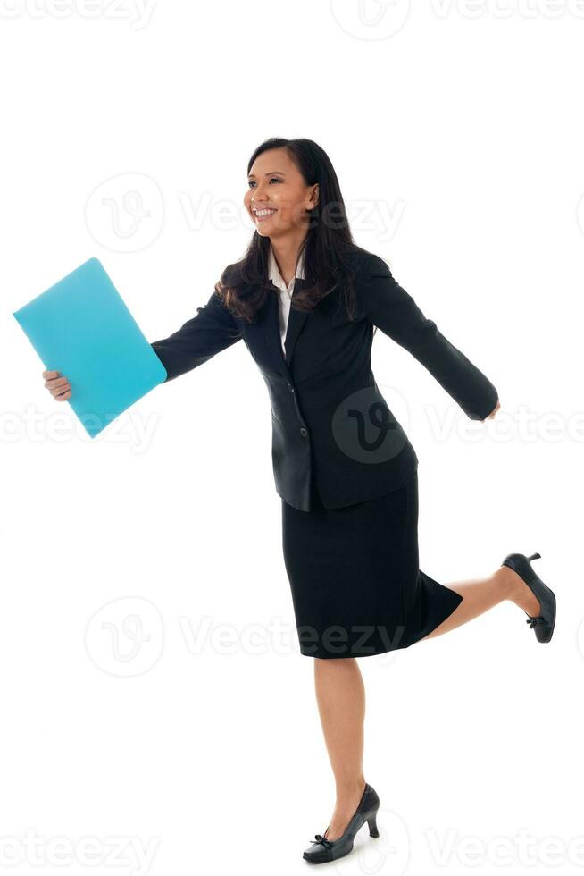 Smiling businesswoman walking with blue folder isolated on white in full body. Mixed-race asian- caucasian brunette female model. photo