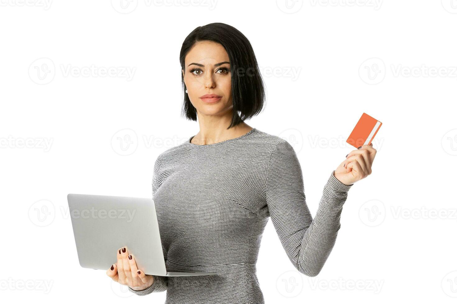 Portrait of confident businesswoman hold laptop and bank card in her hands. Isolated over white background photo