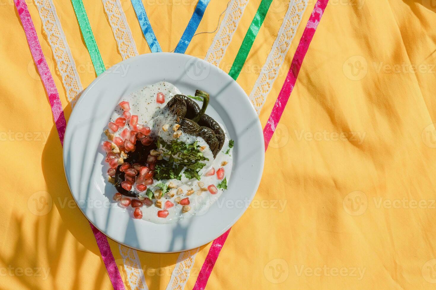 Chiles en Nogada A traditional Mexican dish with stuffed peppers, walnut sauce, and fruit garnish. photo