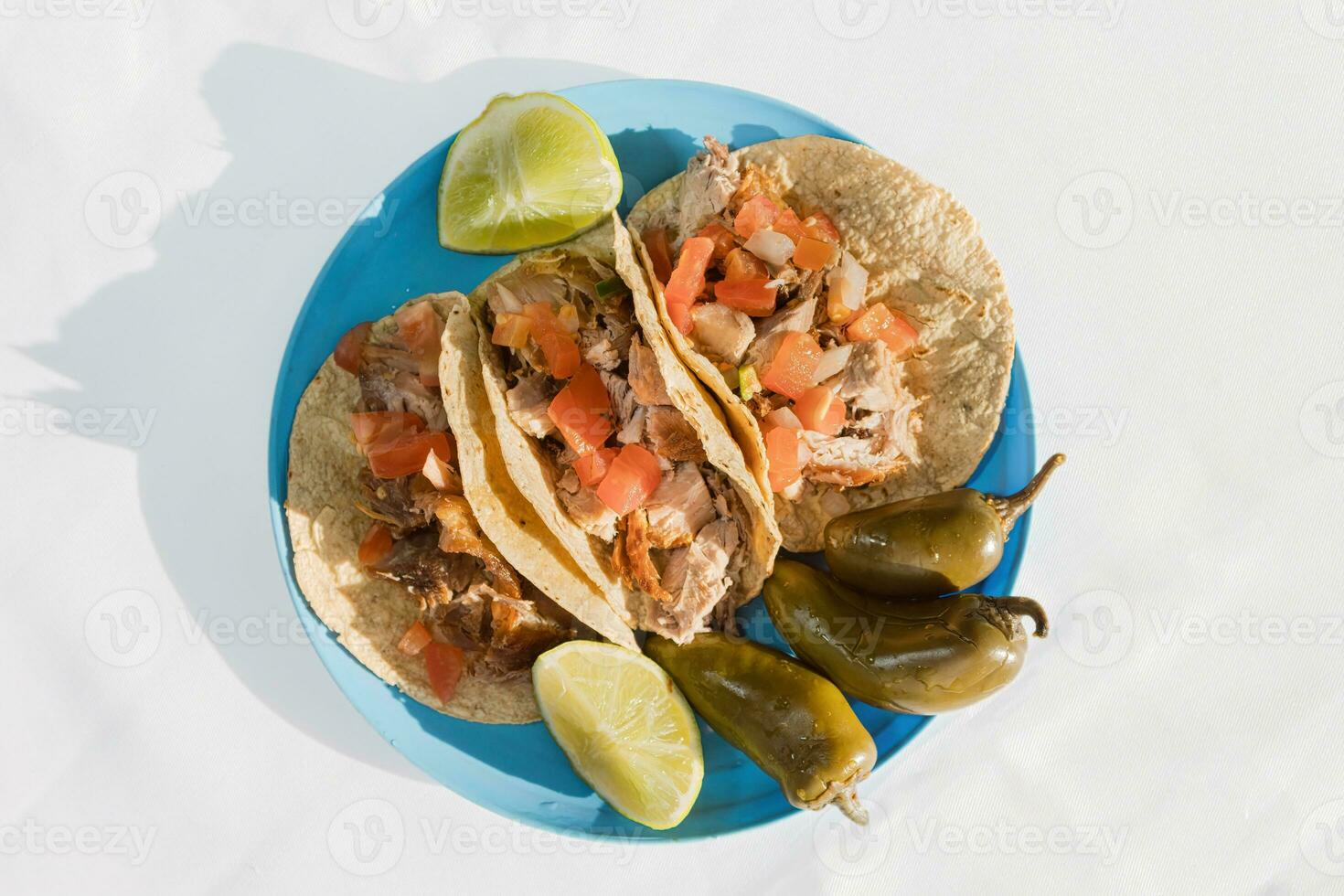 The Mexican carnitas, a flavorful food, is served on tableware with citrus garnish photo