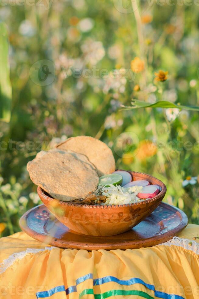 In Mexico, the vibrant red pozole, a traditional comfort food, is served in beautiful pottery bowls photo