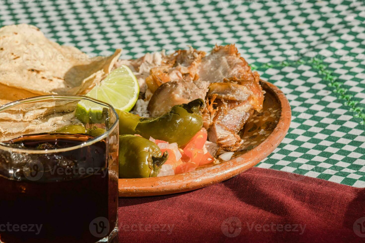 The Mexican carnitas, a delicious food, is served with various condiments on a table with tableware photo