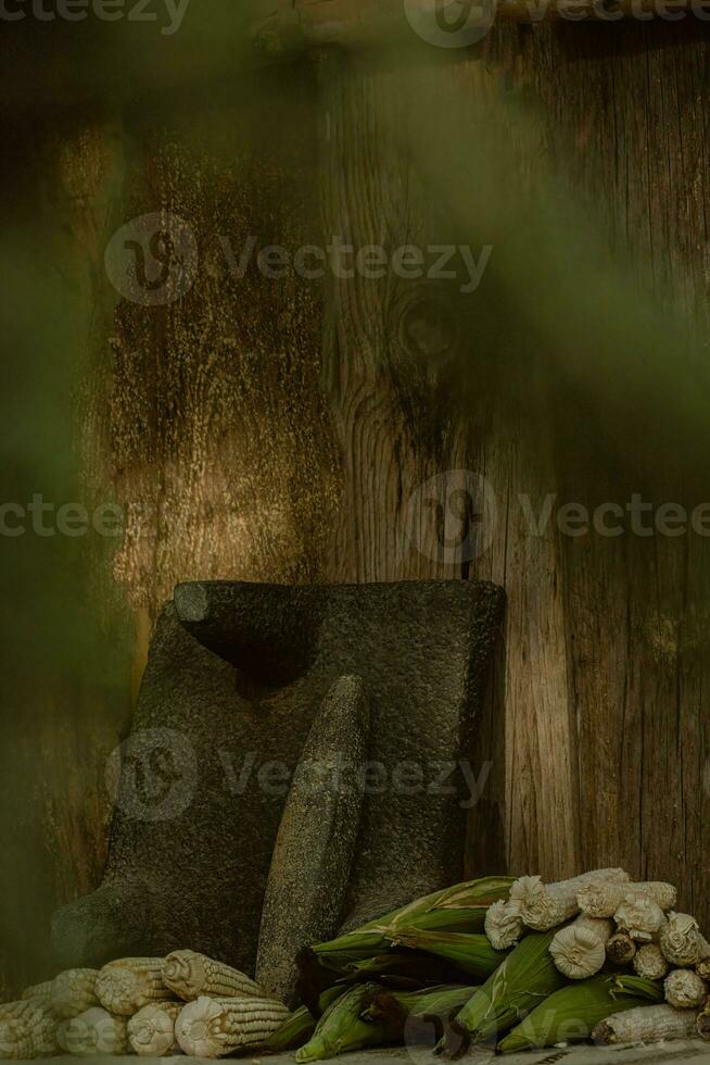 In the rustic kitchen, the wooden metate grinds corn, creating food and artistry photo