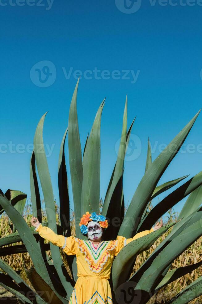 mexicano mujer en vistoso vestir y cráneo maquillaje en el mexicano Desierto cactus foto