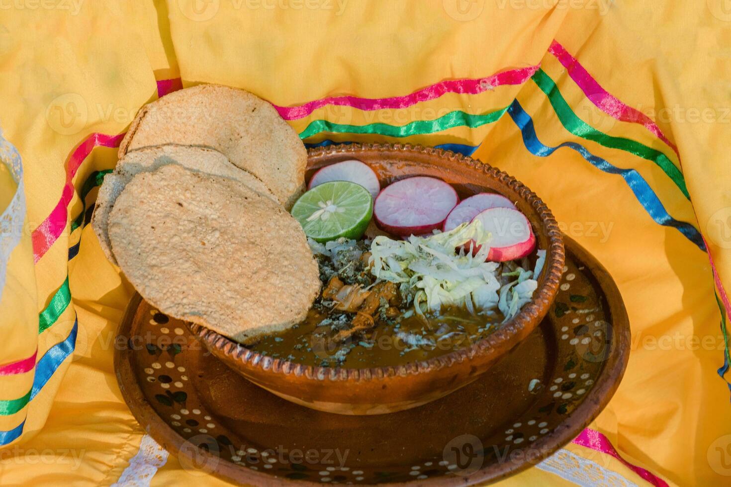 In Mexico, the vibrant red pozole, a traditional comfort food, is served in beautiful pottery bowls photo