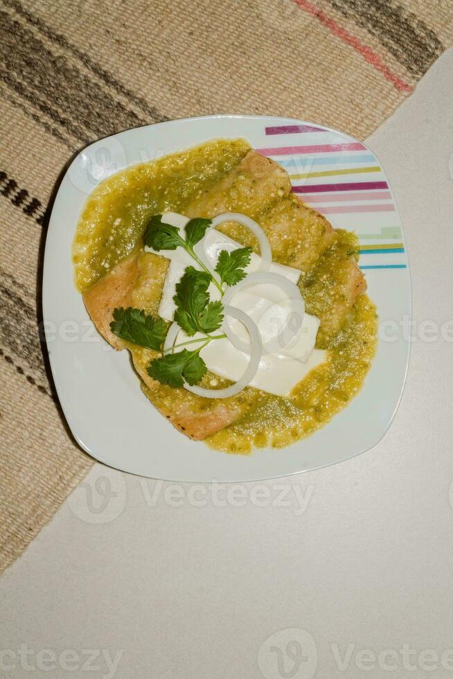 The Mexican enchiladas verdes, a staple food in Mexican cuisine, are served on a plate photo