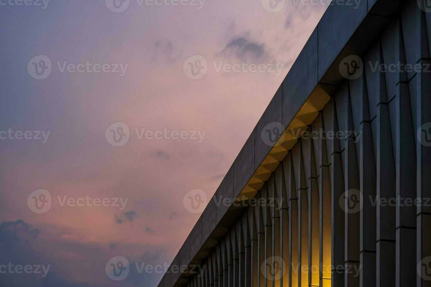 Dusk falls, the city skyline shines with symmetrical buildings and colorful reflections. photo