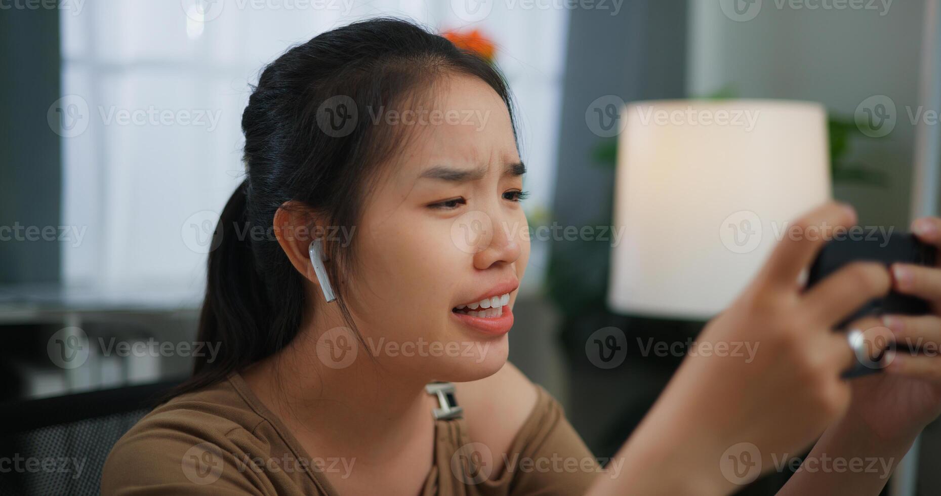 Young Asian woman playing a game on mobile phone photo