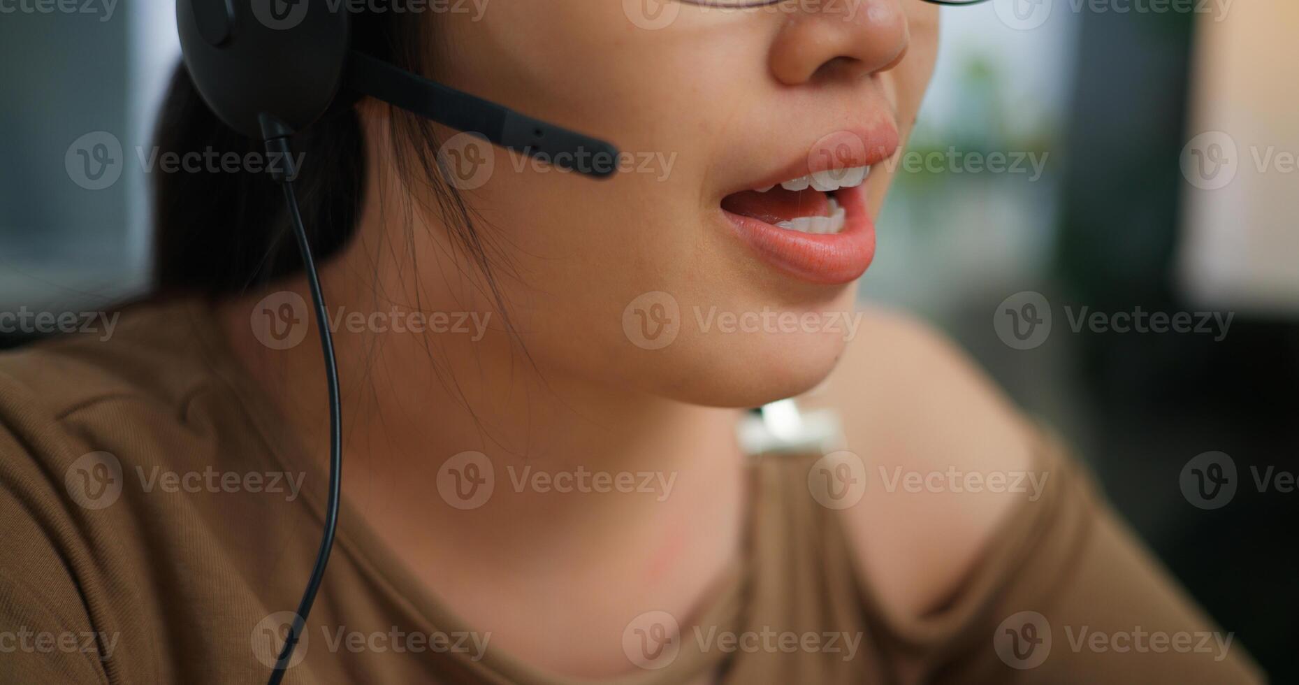 Young Asian woman wearing glasses using a laptop on a desk photo