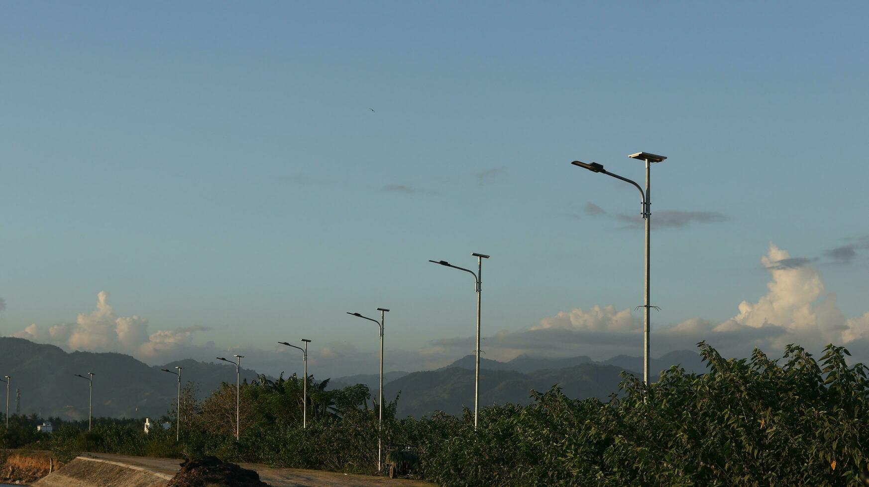 street lamp in the countryside with mountains in the background photo
