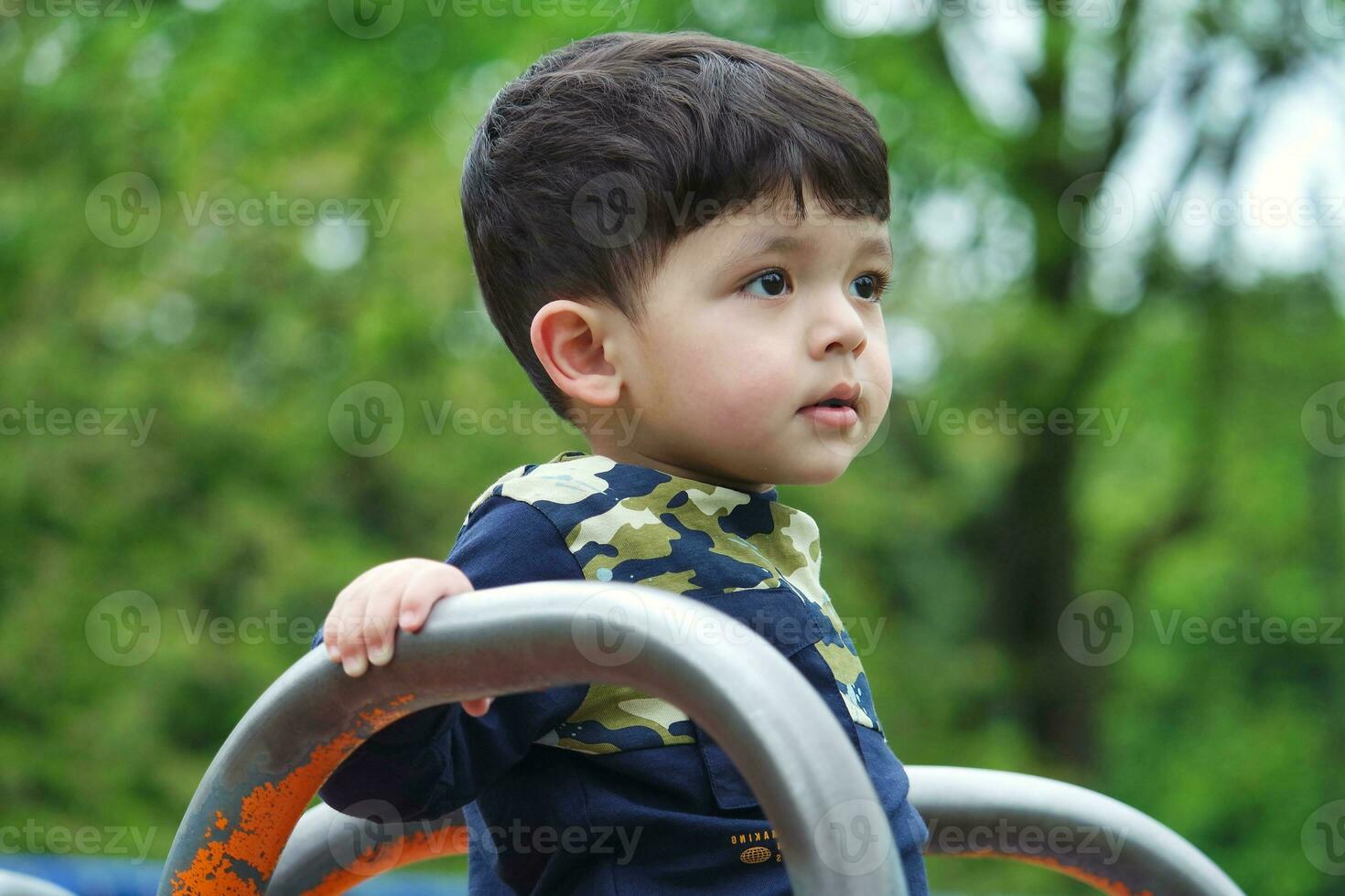 Cute Asian Pakistani Baby is Enjoying The Beautiful Sunny Day at Wardown Children and Public Park of Luton Town of England UK. Low Angle  Image Was Captured on April 03rd, 2023 photo