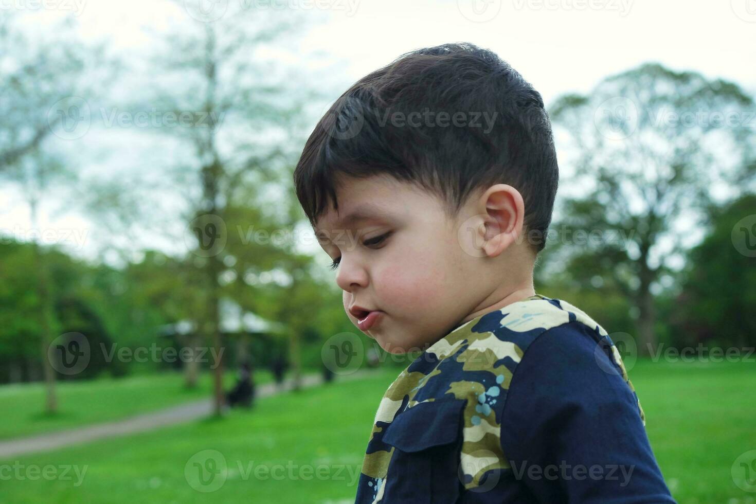 linda asiático pakistaní bebé es disfrutando el hermosa soleado día a Wardown niños y público parque de lutón pueblo de Inglaterra Reino Unido. bajo ángulo imagen estaba capturado en abril 03, 2023 foto
