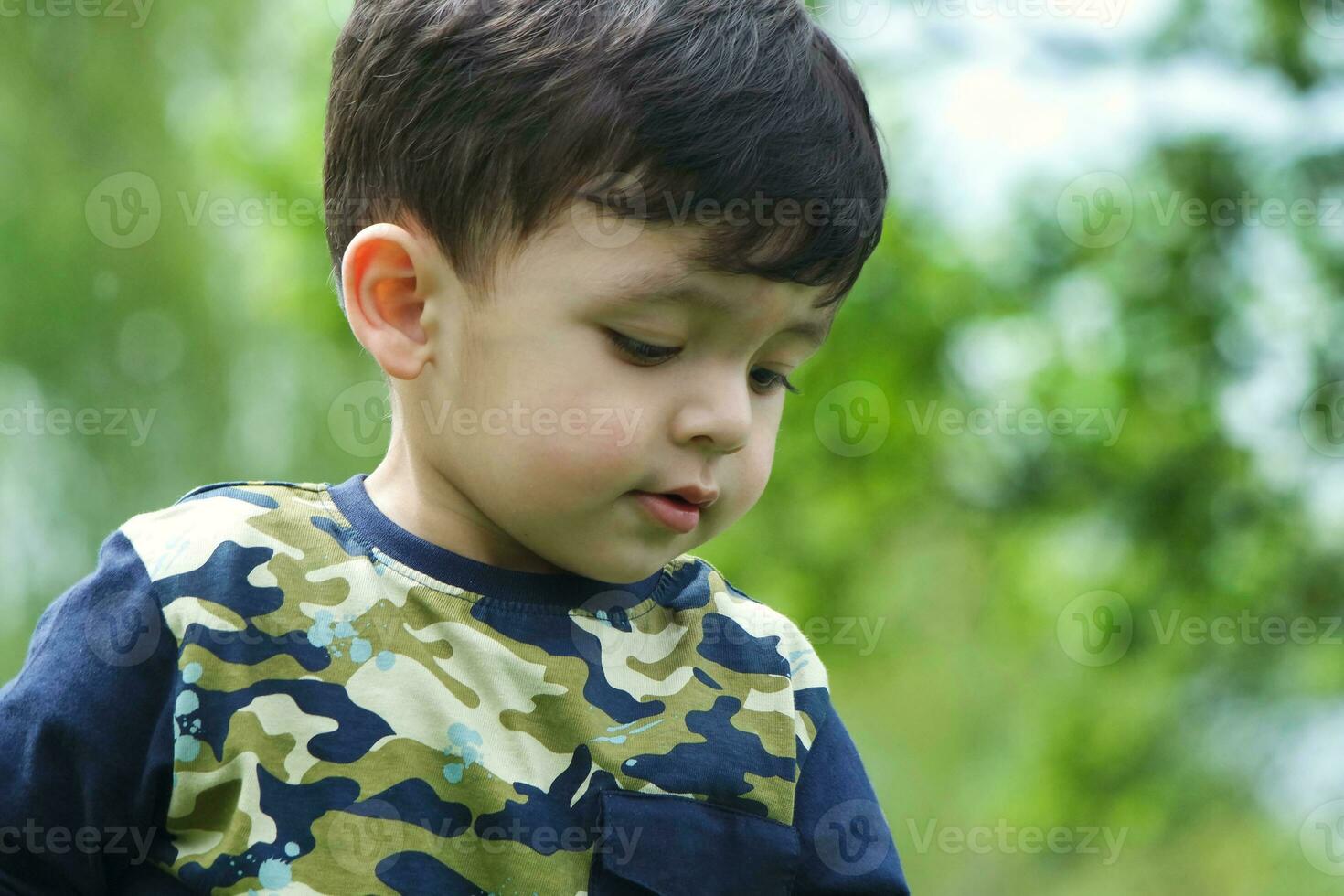 Cute Asian Pakistani Baby is Enjoying The Beautiful Sunny Day at Wardown Children and Public Park of Luton Town of England UK. Low Angle  Image Was Captured on April 03rd, 2023 photo