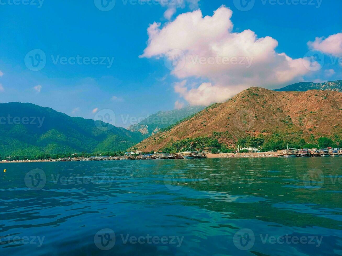 ver desde el mar a el montañas y el azul cielo con nubes foto