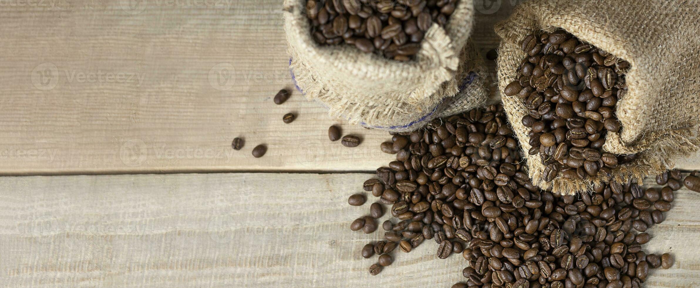 Fresh coffee beans. Coffee beans in bags on a wooden background. View from above. Copy space. Banner photo