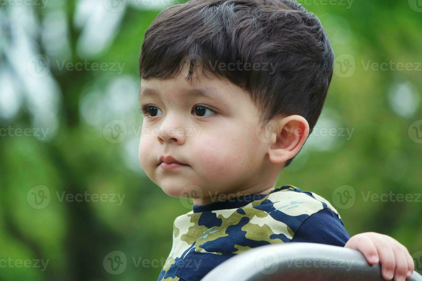 Cute Asian Pakistani Baby is Enjoying The Beautiful Sunny Day at Wardown Children and Public Park of Luton Town of England UK. Low Angle  Image Was Captured on April 03rd, 2023 photo