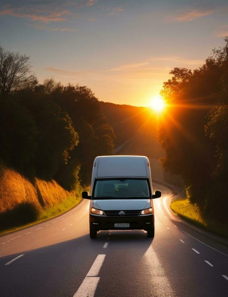 A van driving down a road with the sun setting behind it photo