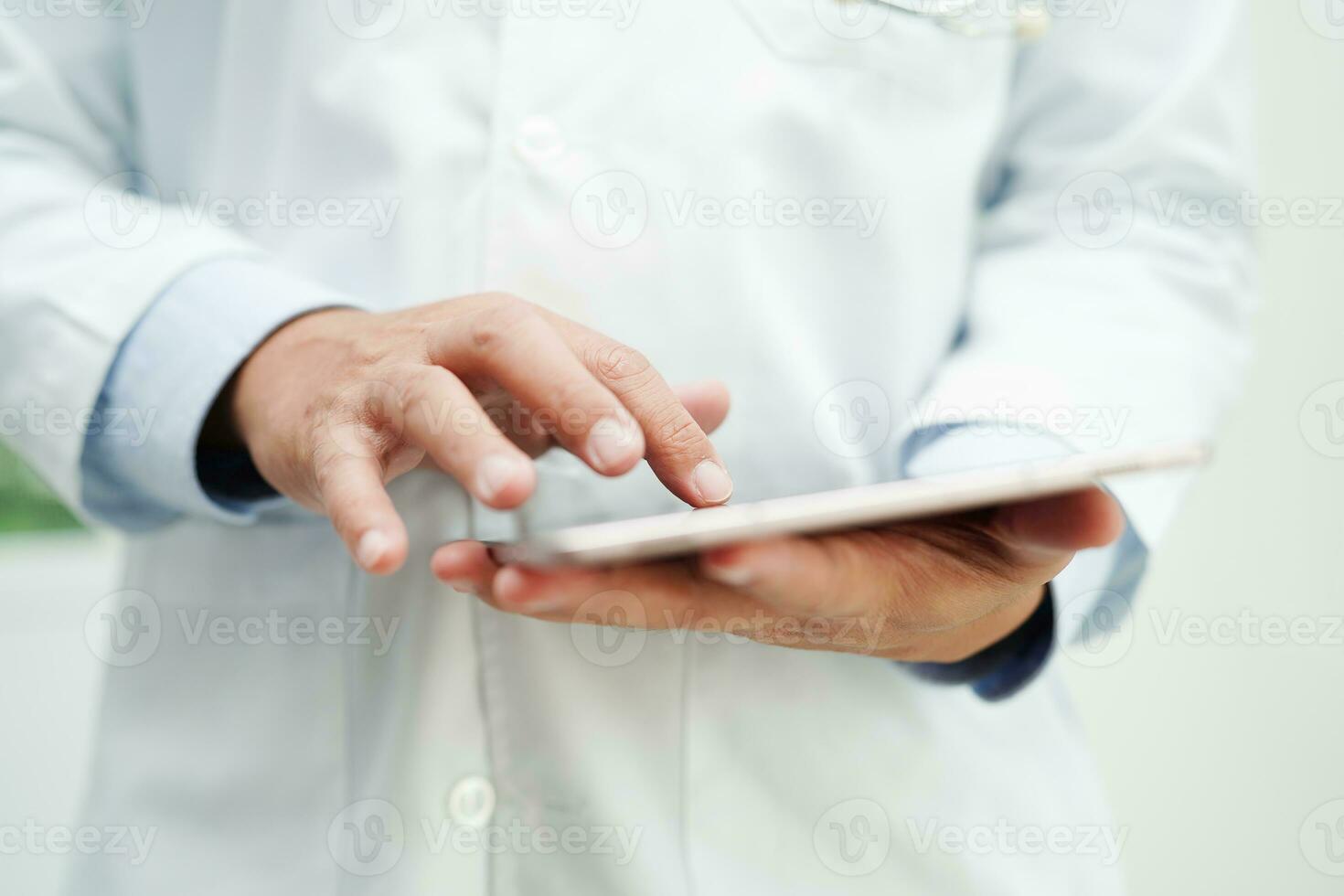 Asian man doctor using tablet computer to reading patient report, check up and search for solve treatment health medical online in hospital. photo