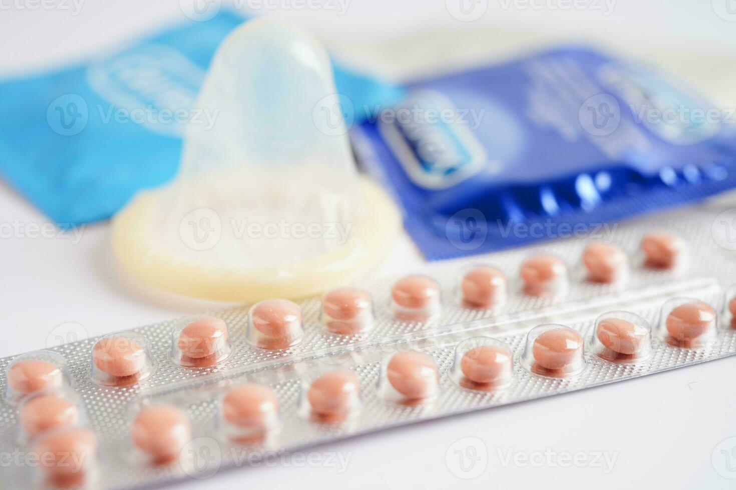 Pregnancy test with birth control pills and condom for female on calendar, ovulation day. photo