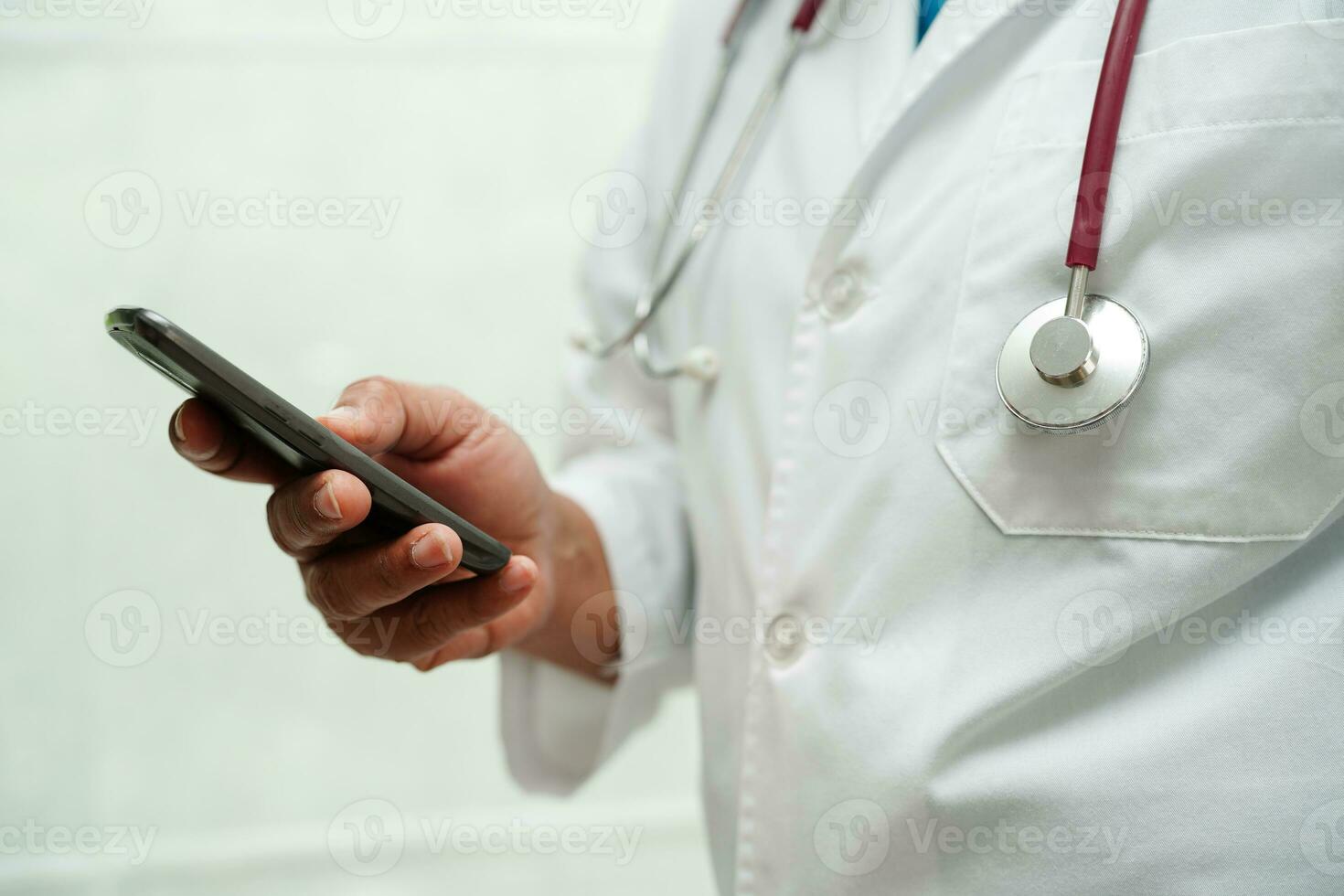 Asian woman doctor holding mobile phone or tablet for search method of treatment patient in hospital. photo