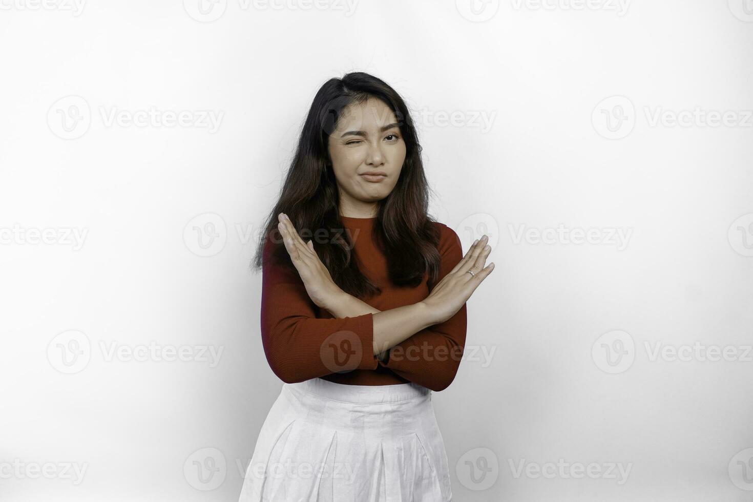 Attractive Asian woman wearing red t-shirt with hand gesture pose rejection or prohibition isolated by white background photo