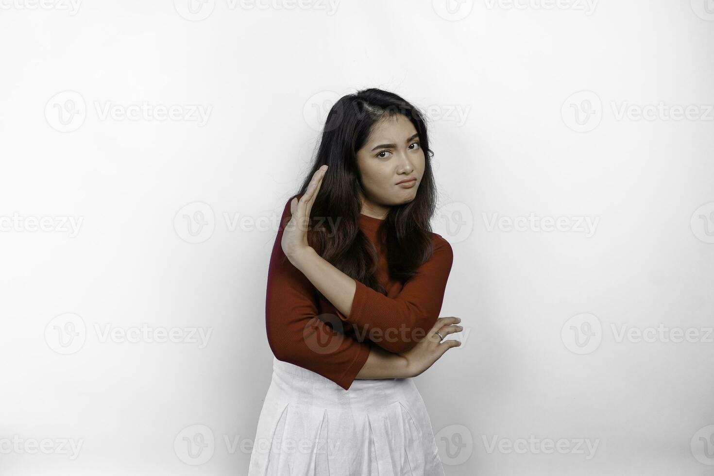 Attractive Asian woman wearing red t-shirt with hand gesture pose rejection or prohibition isolated by white background photo