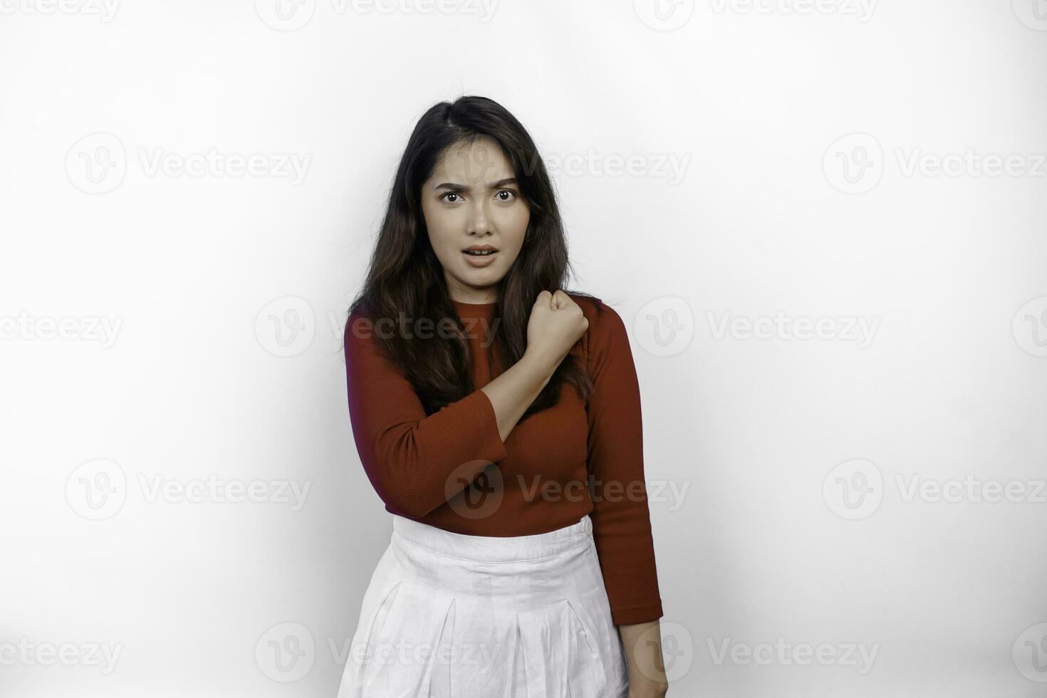 Excited Asian woman wearing a red top showing strong and brave gesture photo