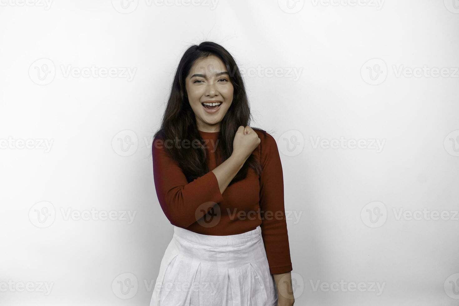 Excited Asian woman wearing a red top showing strong and brave gesture photo