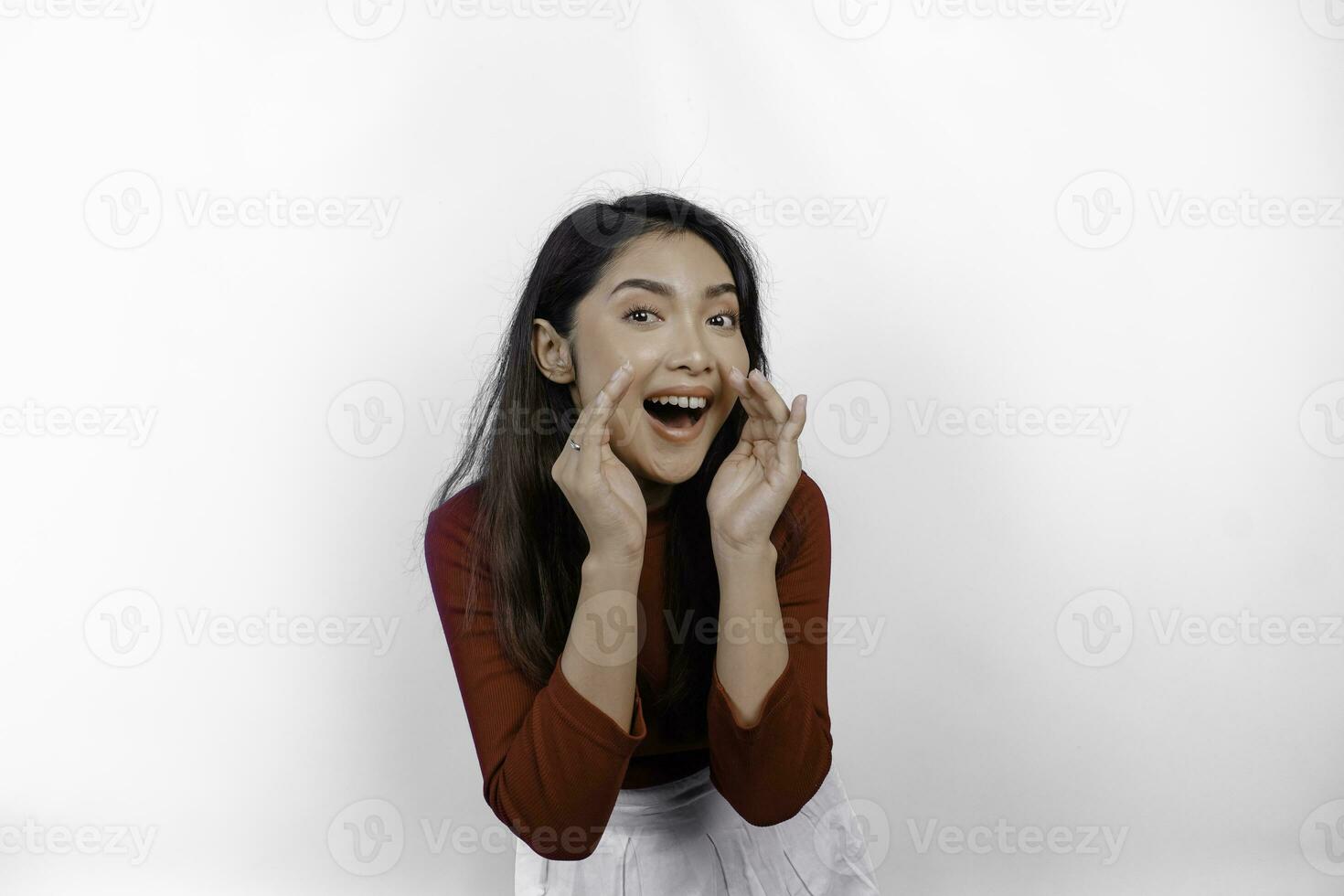 Young beautiful woman wearing a red top shouting and screaming loud with a hand on her mouth. communication concept. photo