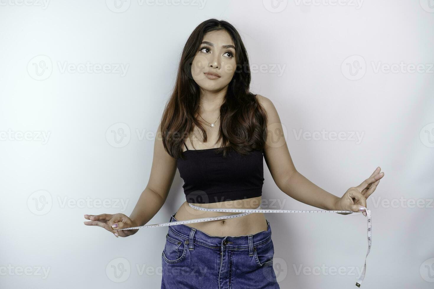 peso pérdida, Delgado cuerpo, sano estilo de vida concepto. ajuste aptitud asiático niña medición su cintura con medición cinta, aislado por blanco antecedentes foto