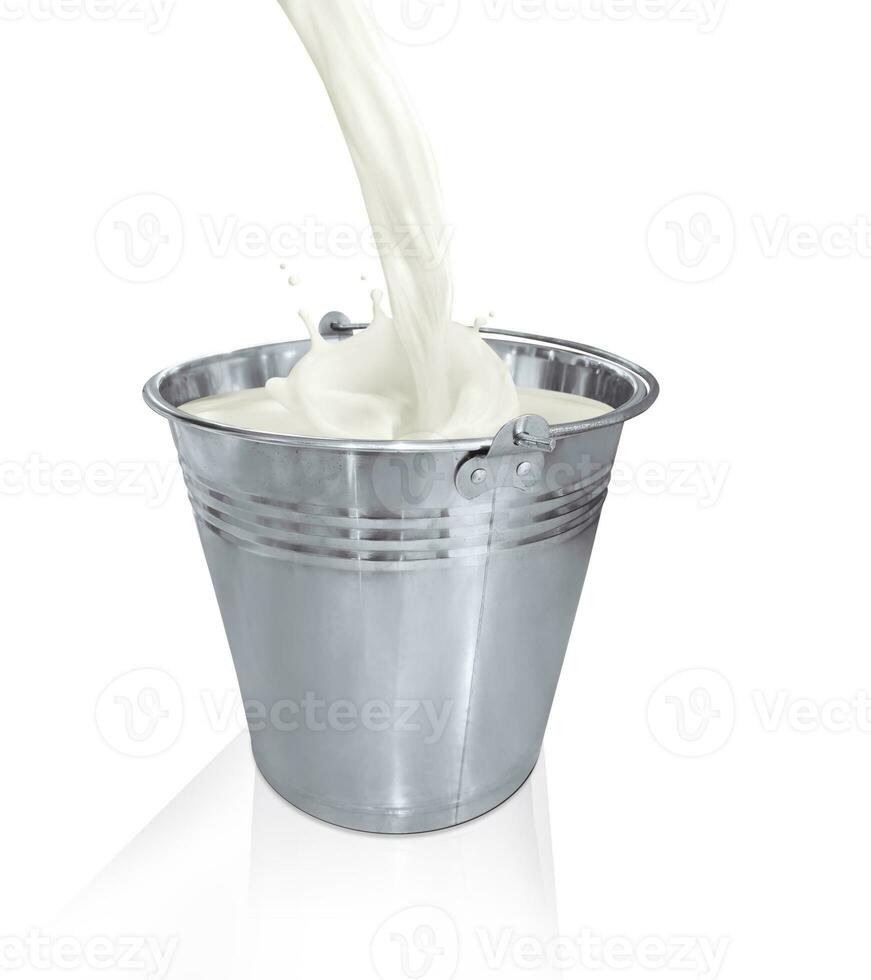 Poured milk into metal bucket with splash on white background photo